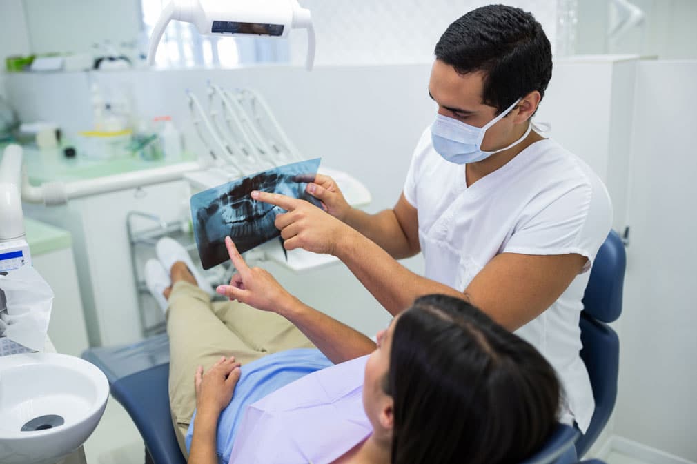 dentist examining x-ray with patient